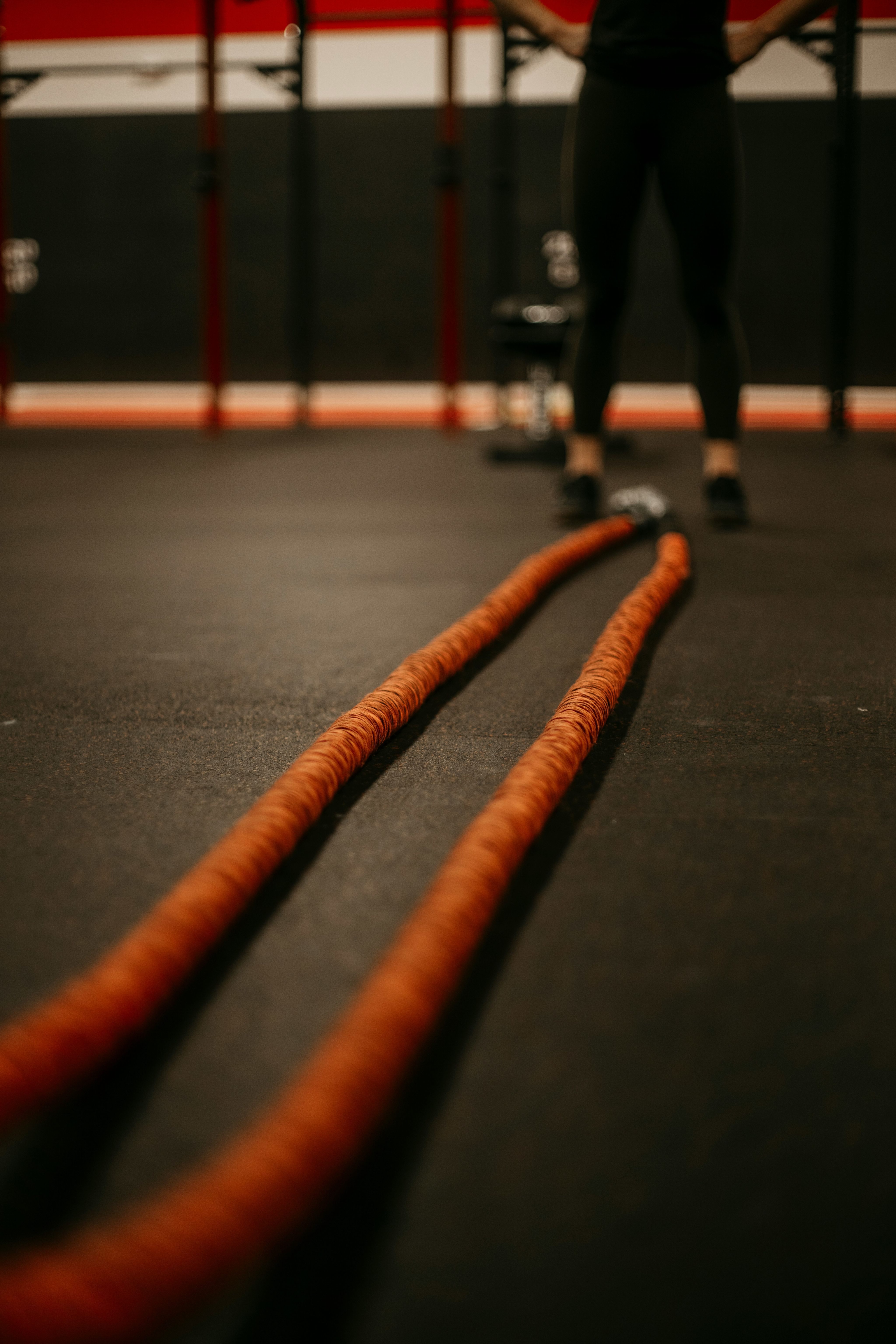 a man standing in a gym holding a rope